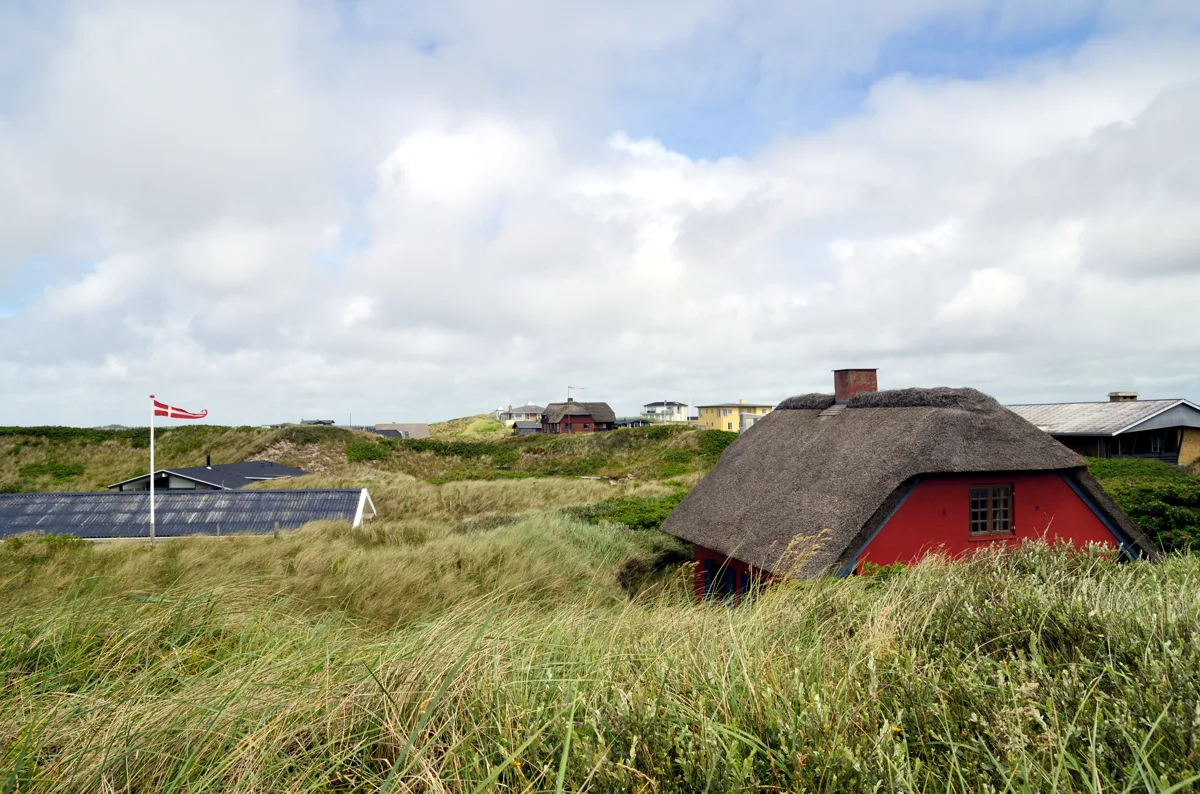 Ferienhäuser zwischen grasbewachsenen Dünen in Henne Strand